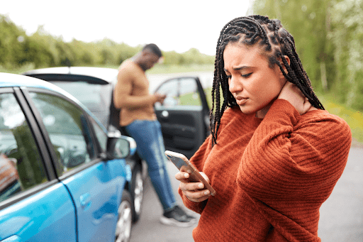 woman standing next to car collision